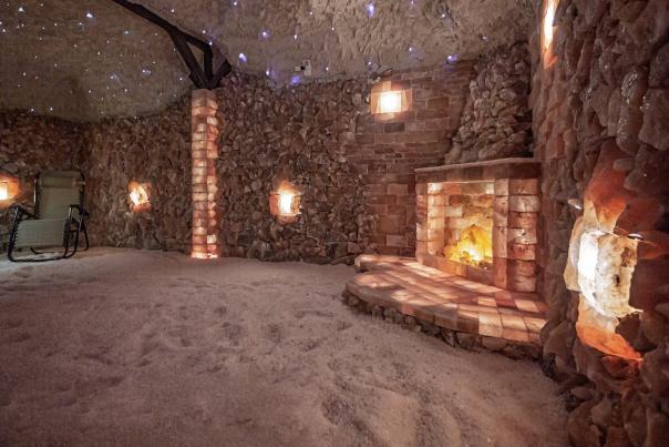 Beautiful Salt Cave built with Himalayan Salt bricks illuminated with fairy lights, glowing salt crystals and a faux fireplace made with glowing salt blocks.