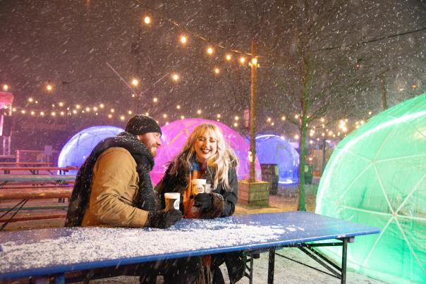 Couple enjoys drinks outside in the snow at Land-Grant Brewing Co.