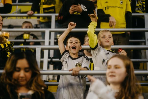Two young boys cheering for the Columbus Crew