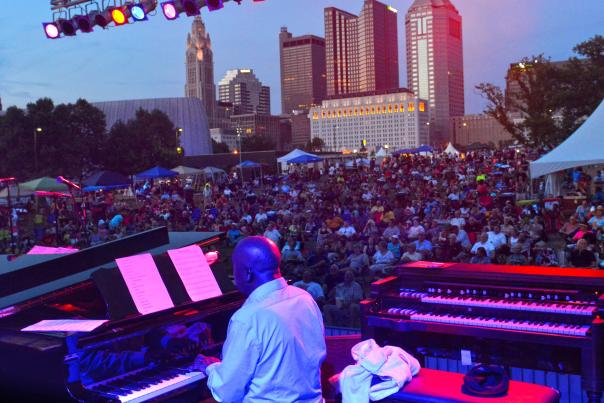 View from stage of band playing to crowd with skyline in background during Jazz & Rib Festival