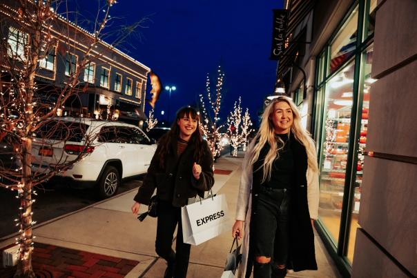 Two women shopping with holiday decor behind them