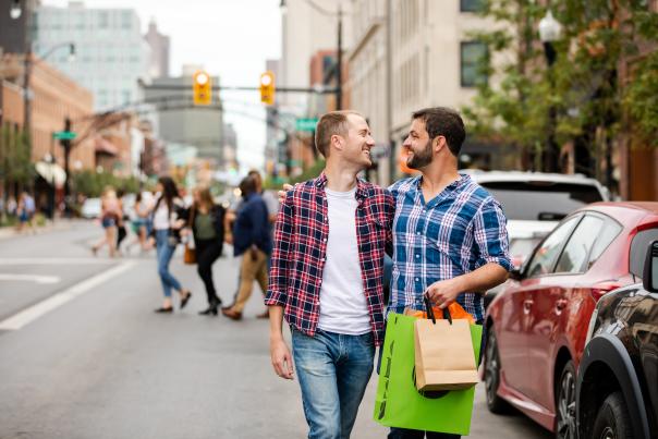 Two men with arms wrapped around each other, smiling while shopping in the Short North