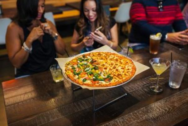 Two women enjoying Donatos Pizza