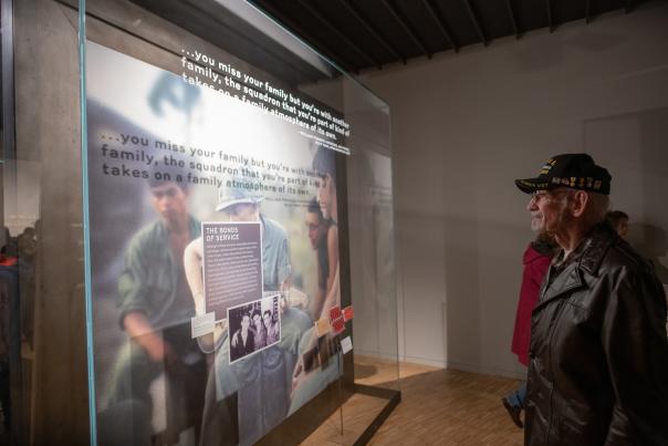 Man in Korea Vet hat observes exhibit at National Veterans Memorial and Museum