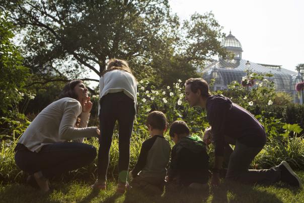 A family kneels down in flowers outside of Franklin Park Conservatory and Botanical Gardens