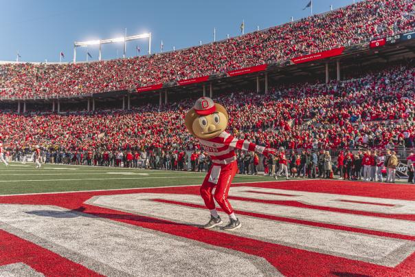 Brutus mascot dancing in Ohio Stadium with full crowd behind him