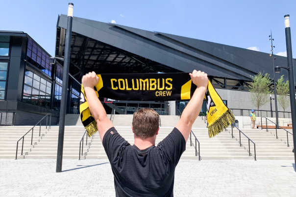 Crew fan holding up scarf outside new Lower.com Field