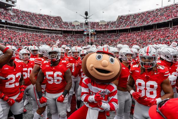 Brutus the Buckeye surrounded by Ohio State football players