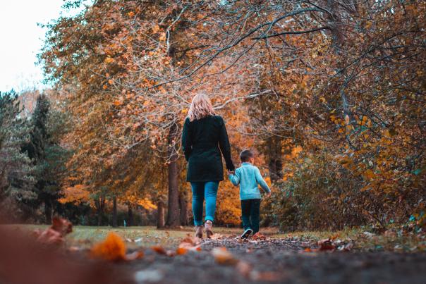 Mother and son holding hands during a walk in the fall