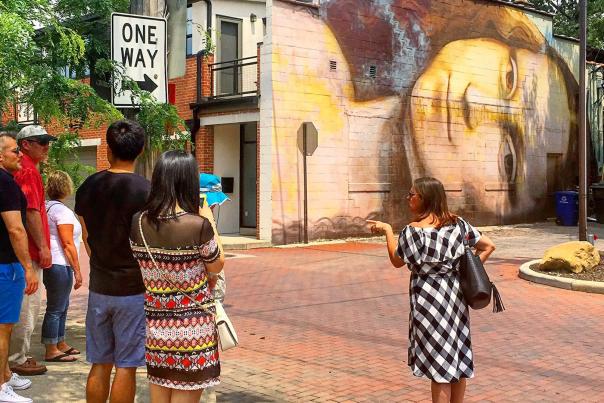 Group stands outside in front of Short North mural