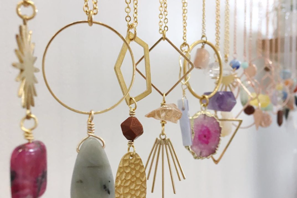 Dangling pendant necklaces featuring multicolored stones and metals
