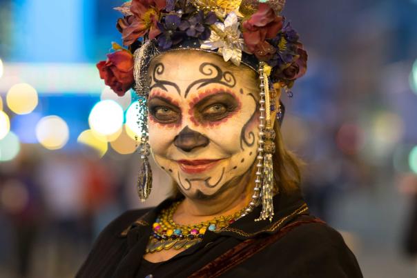 A woman has her face painted for Dia de los Muertos during Highball Halloween