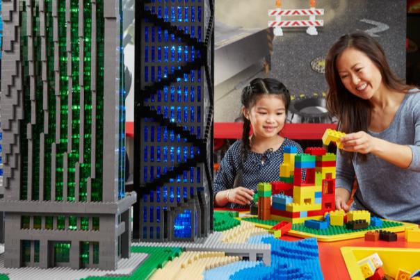 Mother and daughter playing with legos next to lego buildings at LEGOLAND Discovery Center
