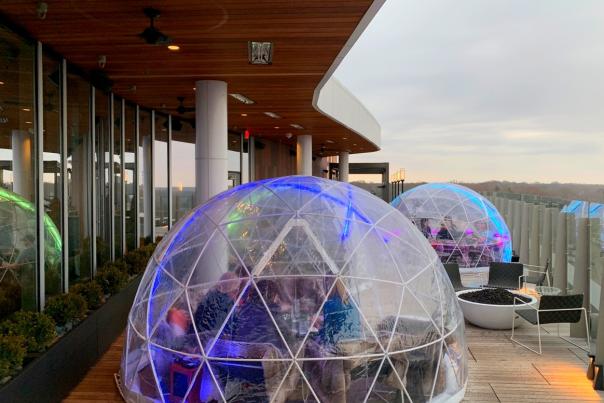 People drinking and dining inside large plastic domes on Vaso Dublin's rooftop lounge