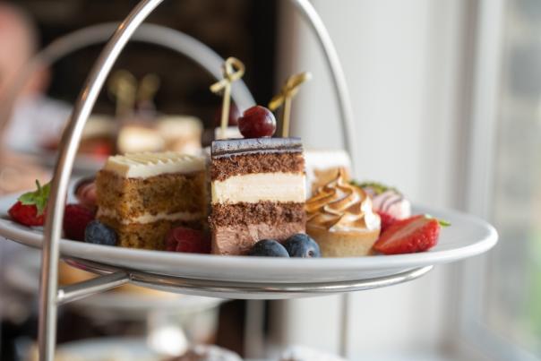 A selection of cakes, fruit and sweet desserts on a white plate