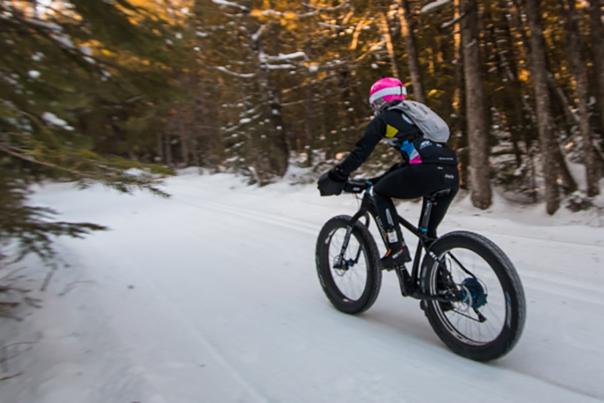 Fat Tire Biker going down trail in winter