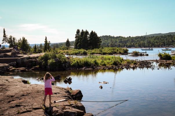A young child looks over the harbor in Grand Marais