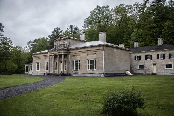 A large stone historical building called Hyde Halle with a pathway and a grassy front lawn.