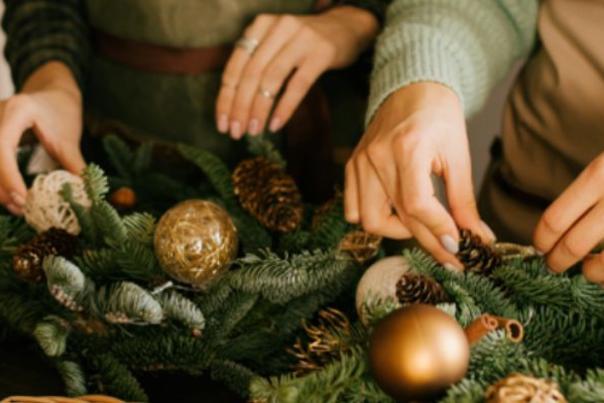 Two people making Christmas wreaths