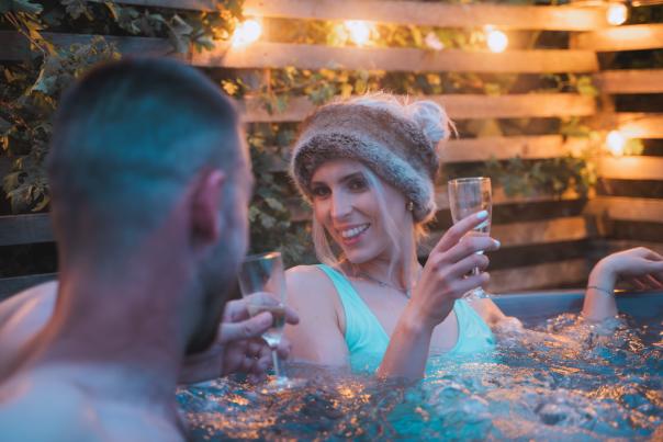 A couple enjoy a glass of wine in a hot tub at Cotswold Farm Park