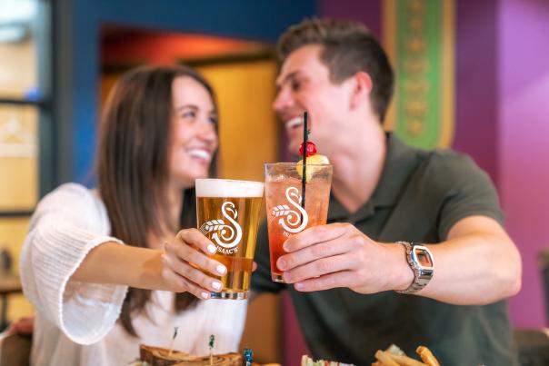 Couple doing cheers with beer at Isaac's Craft Kitchen & Brewery in Lemoyne