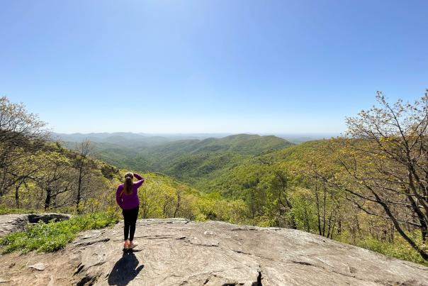 Girl standing on rock overlooking mountains