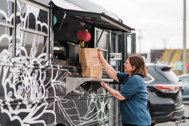 A woman takes her order to go at a popular food truck in Dayton, OH.