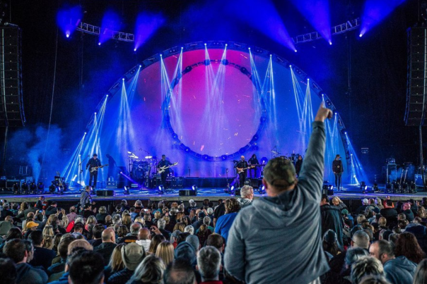 An audience member stands during a concert at Rose Music Center