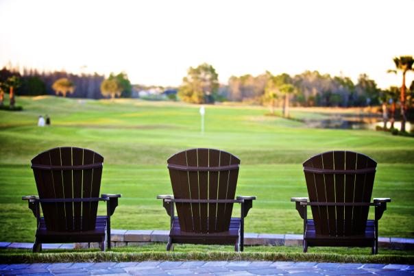 Three Adirondack chairs overlook the beautiful greens at LPGA International world-class golf course