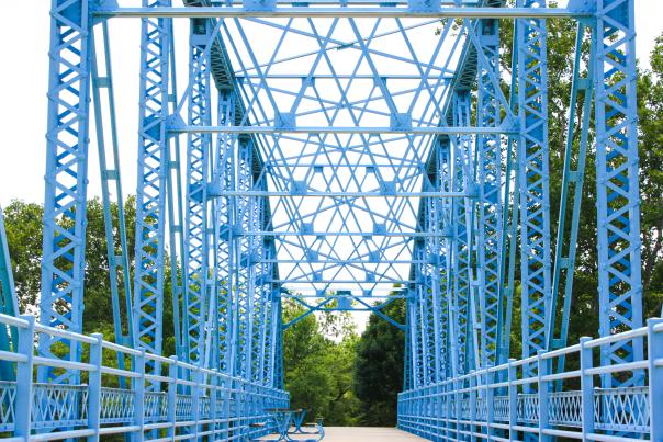 blue bridge at the decatur county park with trees in the background