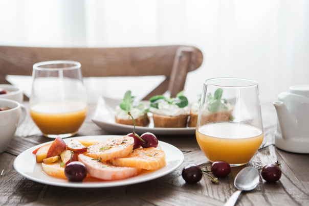 Table setting at brunch with orange juice and fresh fruit