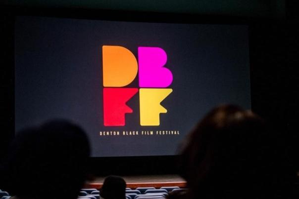 People in a dark theatre looking at the Denton Black Film Festival logo