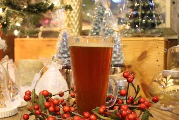 glass of wassail on a table surrounded by christmas decorations