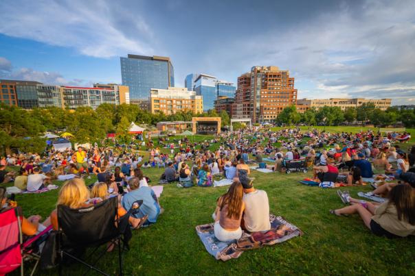 A crowd gathers on blankets to hear live music at Summer Sessions in Denver, Colorado.
