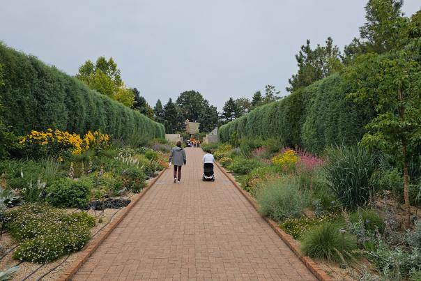 Two women, one in an electric scooter, going down a path at Denver Botanic Gardens