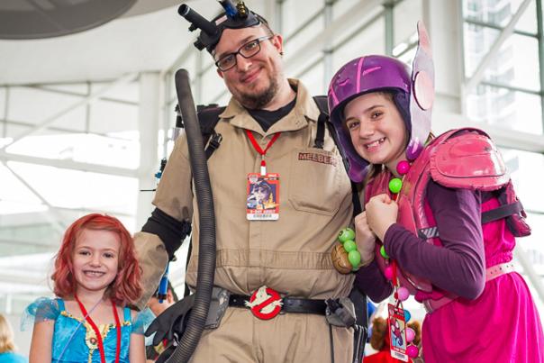A family of three poses in costumes at Fan Expo Denver.
