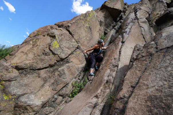 A rock climber reaches for a hold at a crag near Denver