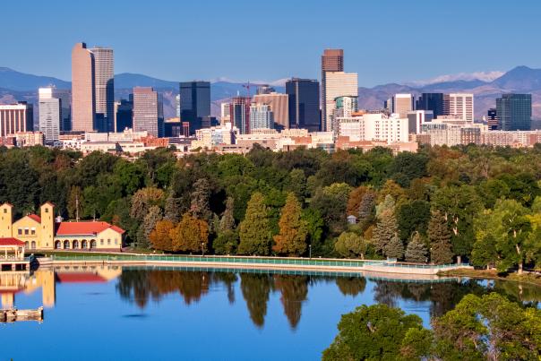 Denver skyline with the lake at City Park in the foreground and the mountains in the background.