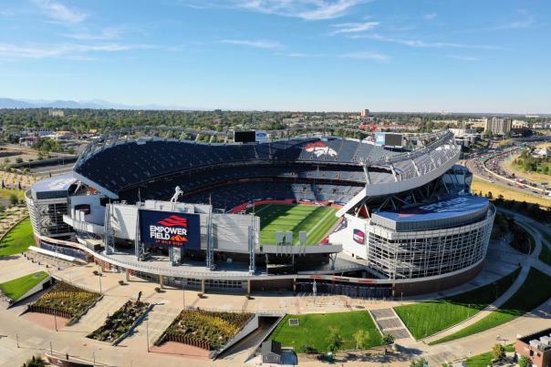 An aerial view of Empower Field at Mile High on a blue-sky day