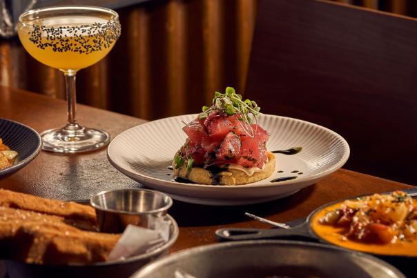 A feast of dishes, including a tuna-topped meal and a sesame-sprinkled cocktail at Work & Class in Denver