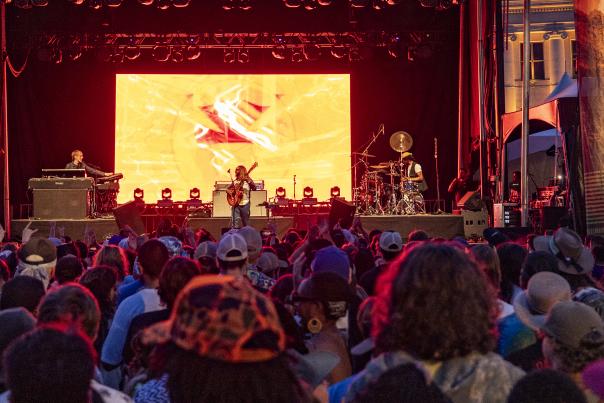 A crowd cheers at an outdoor concert at Outside Days in Denver, Colorado.