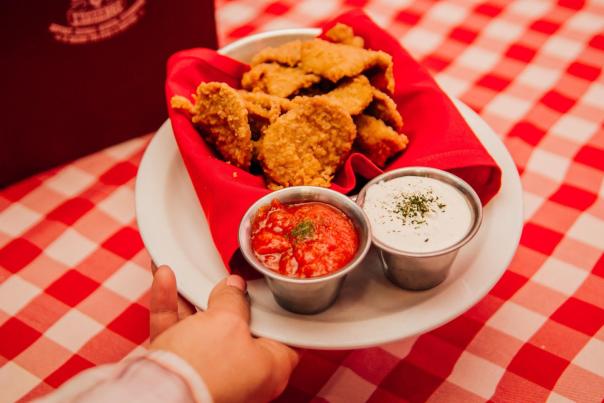 A server places a plate of fried Rocky Mountain Oysters on a table at Buckhorn Exchange