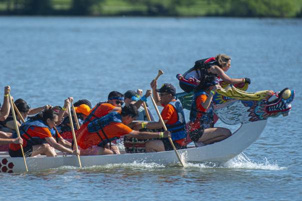 A dragon boat team paddles on a reservoir in Denver