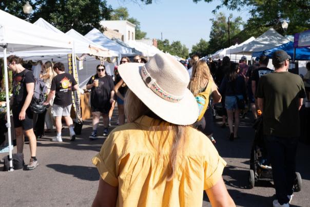 A person is walking through South Pearl Street Farmers' Market