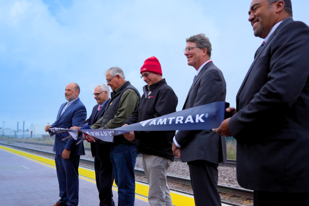 Devils Lake North Dakota, leaders and contributors to the new Amtrak station pose to cut a ribbon honoring the new train station.