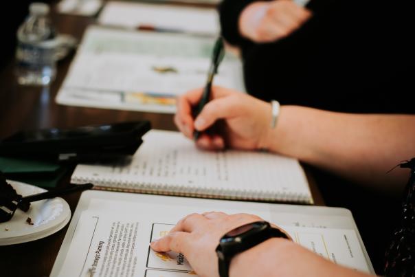 A person taking notes and writing in a binder.