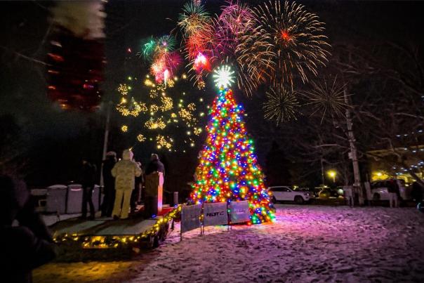 Devils Lake, North Dakota holiday event and Christmas tree with fireworks in the night sky.