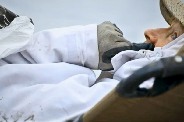 Snow goose hunter wearing white laying down in a field in Devils Lake, ND.