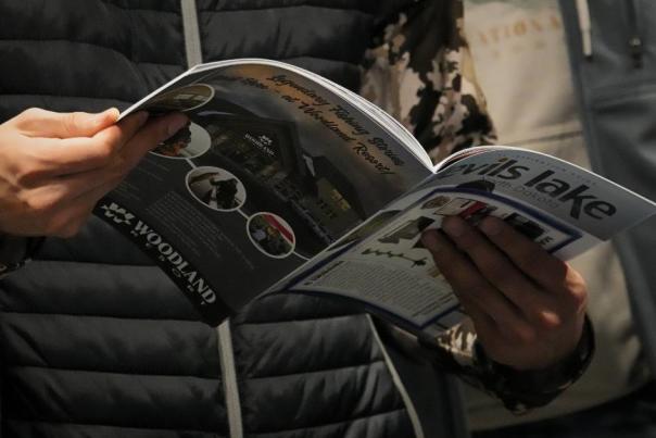 Mad at ice fishing show holding the Devils Lake ice fishing guide and lodging booklet.