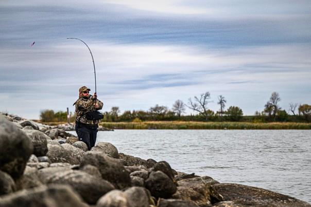 Man fishing on the rocky shoreline of Devils Lake, ND.